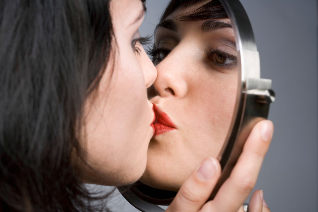A31P2H Woman kissing her reflection in mirror