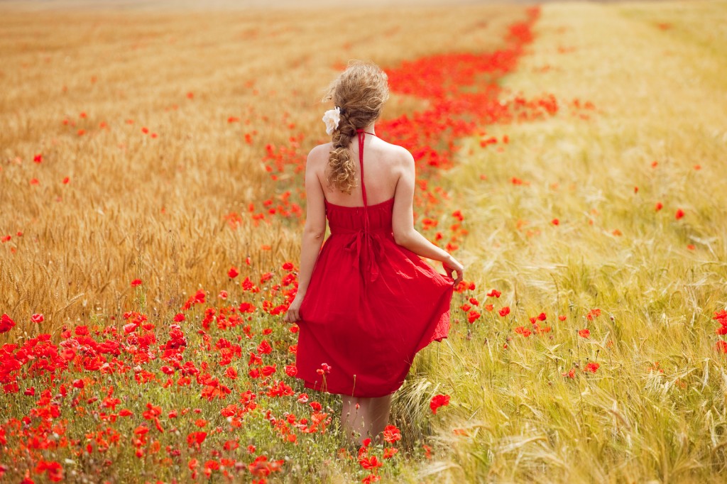 woman-walking-red-meadow-red-flowers-26374541