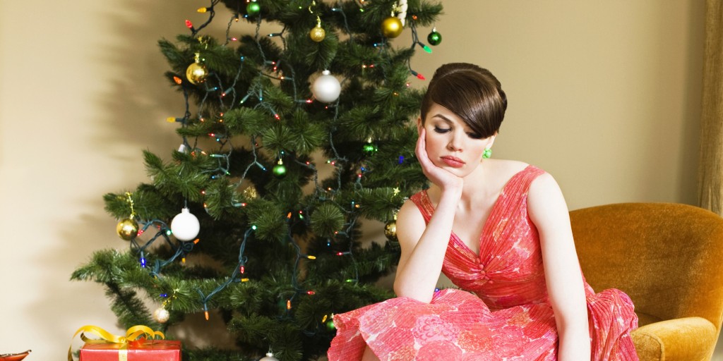 unhappy woman sitting next to christmas tree